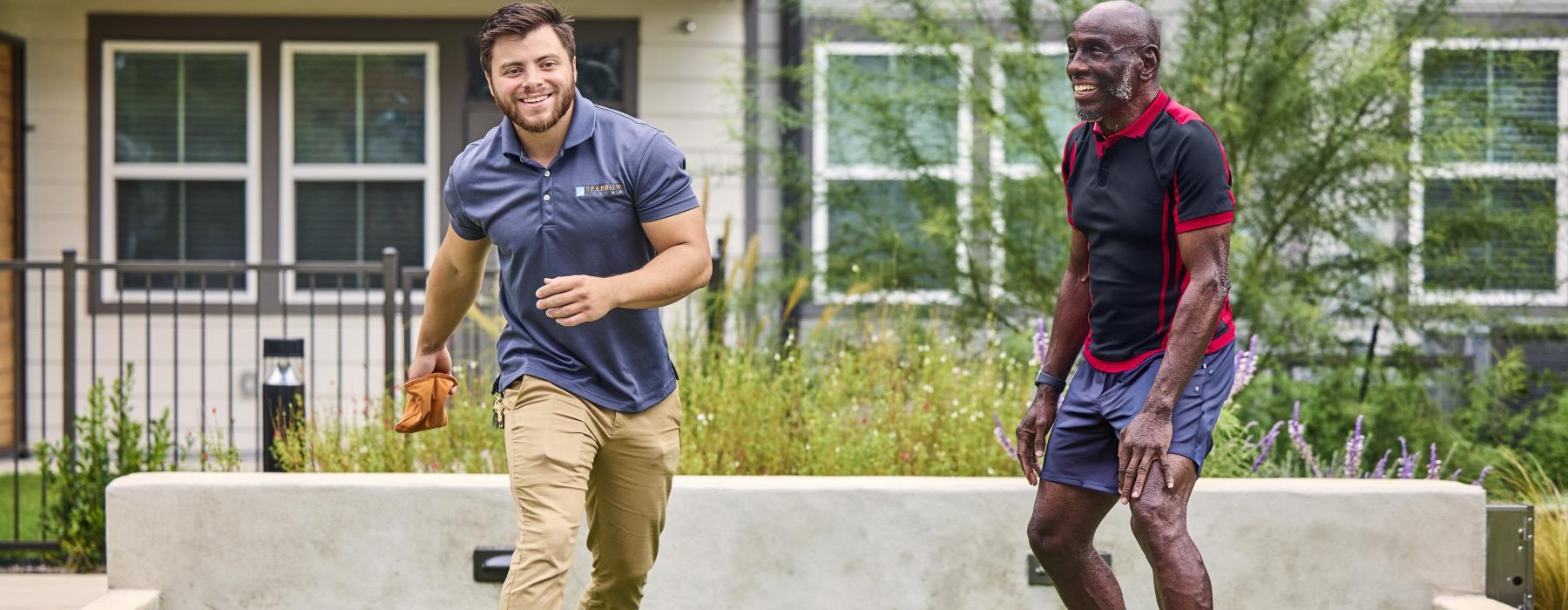 a couple of men playing cornhole