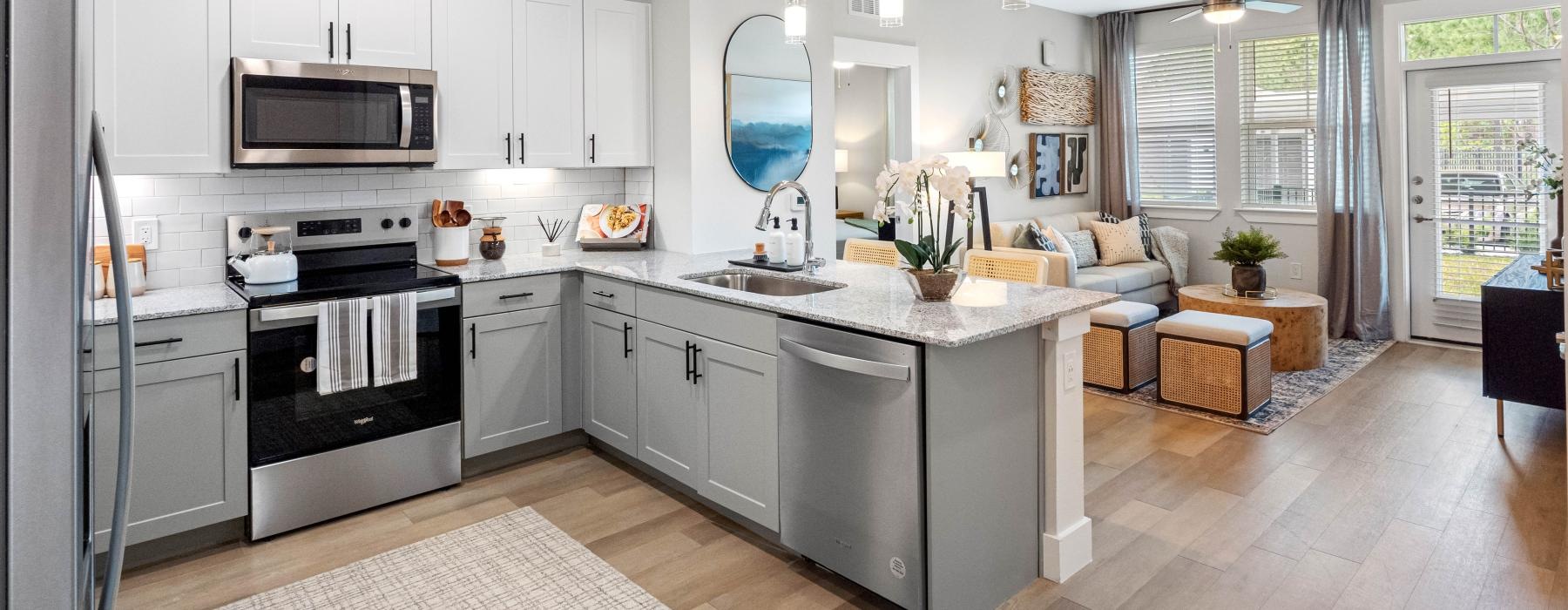 a kitchen with white cabinets leading into a living room